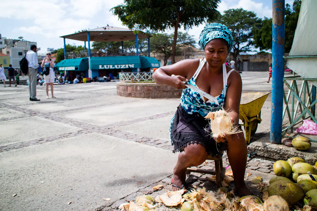 A woman preparing coconuts at a market in Cape Verde.